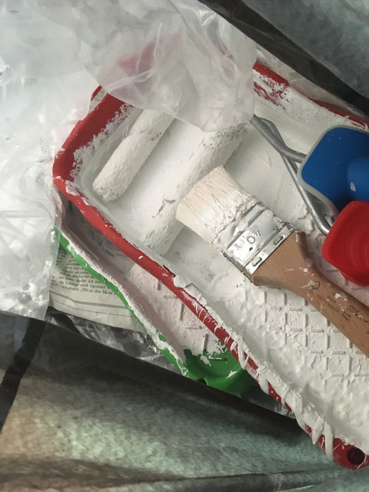 Witte muurverf, kwast, twee rollertjes, afplaktape